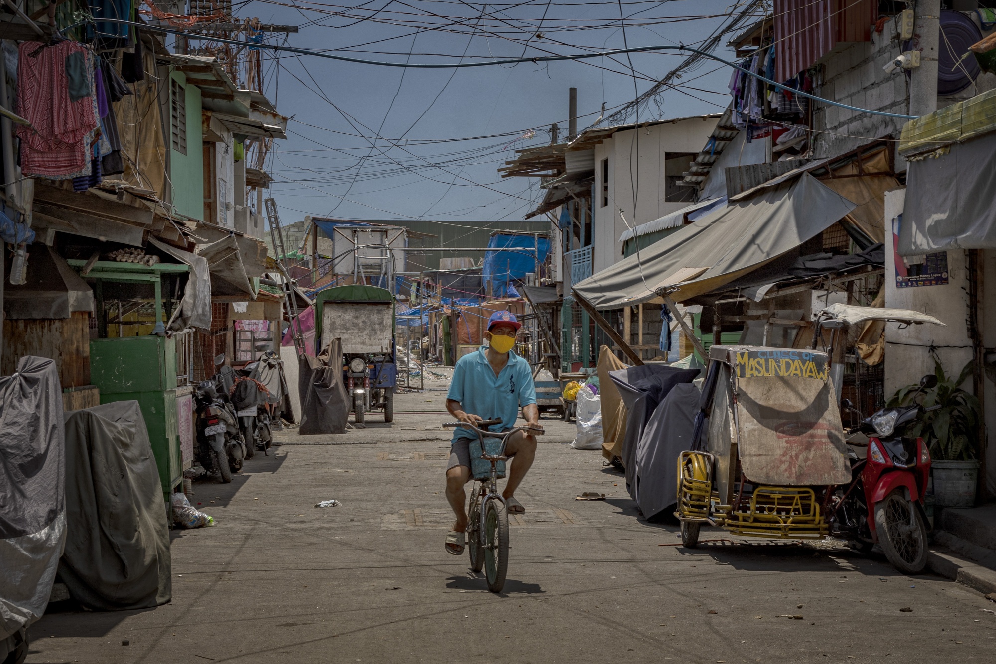A man riding a bicycle in a street in the Philippines