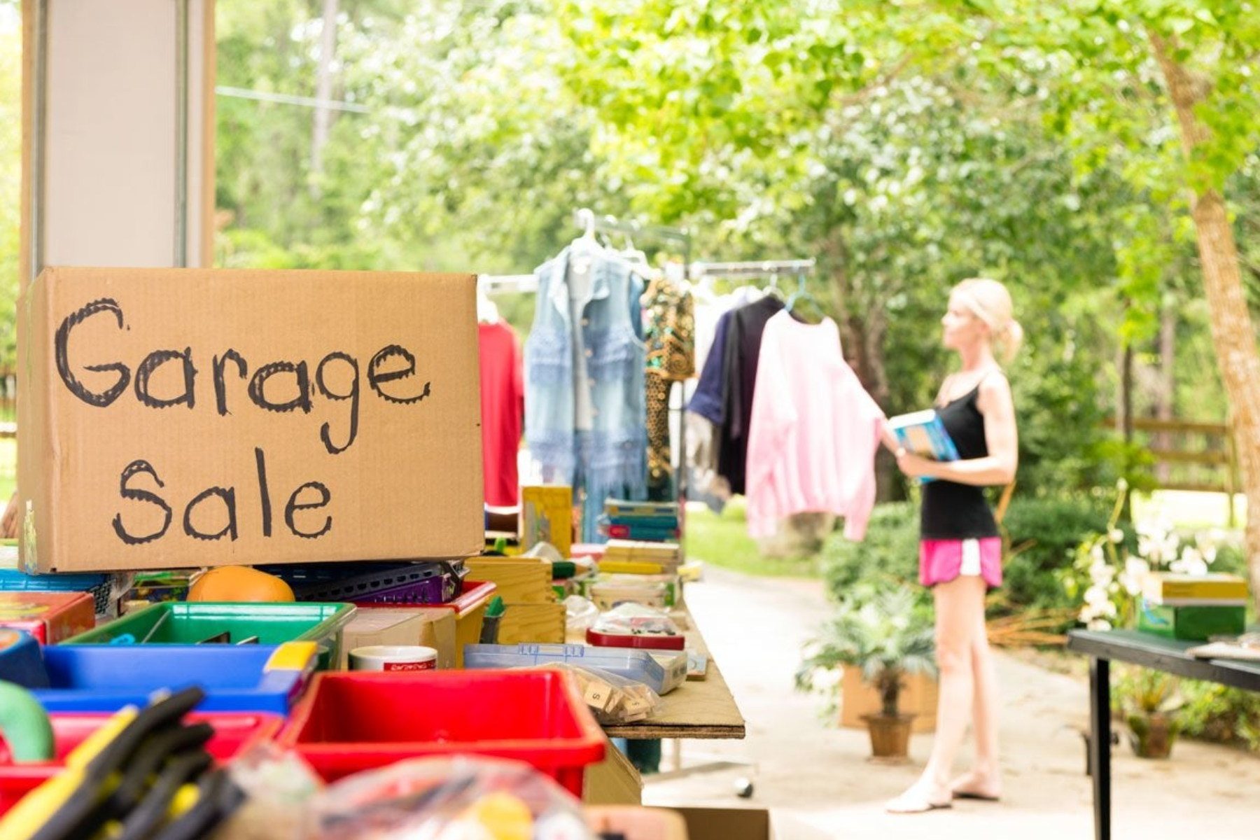 A woman is arranging the clothes for her garage sale