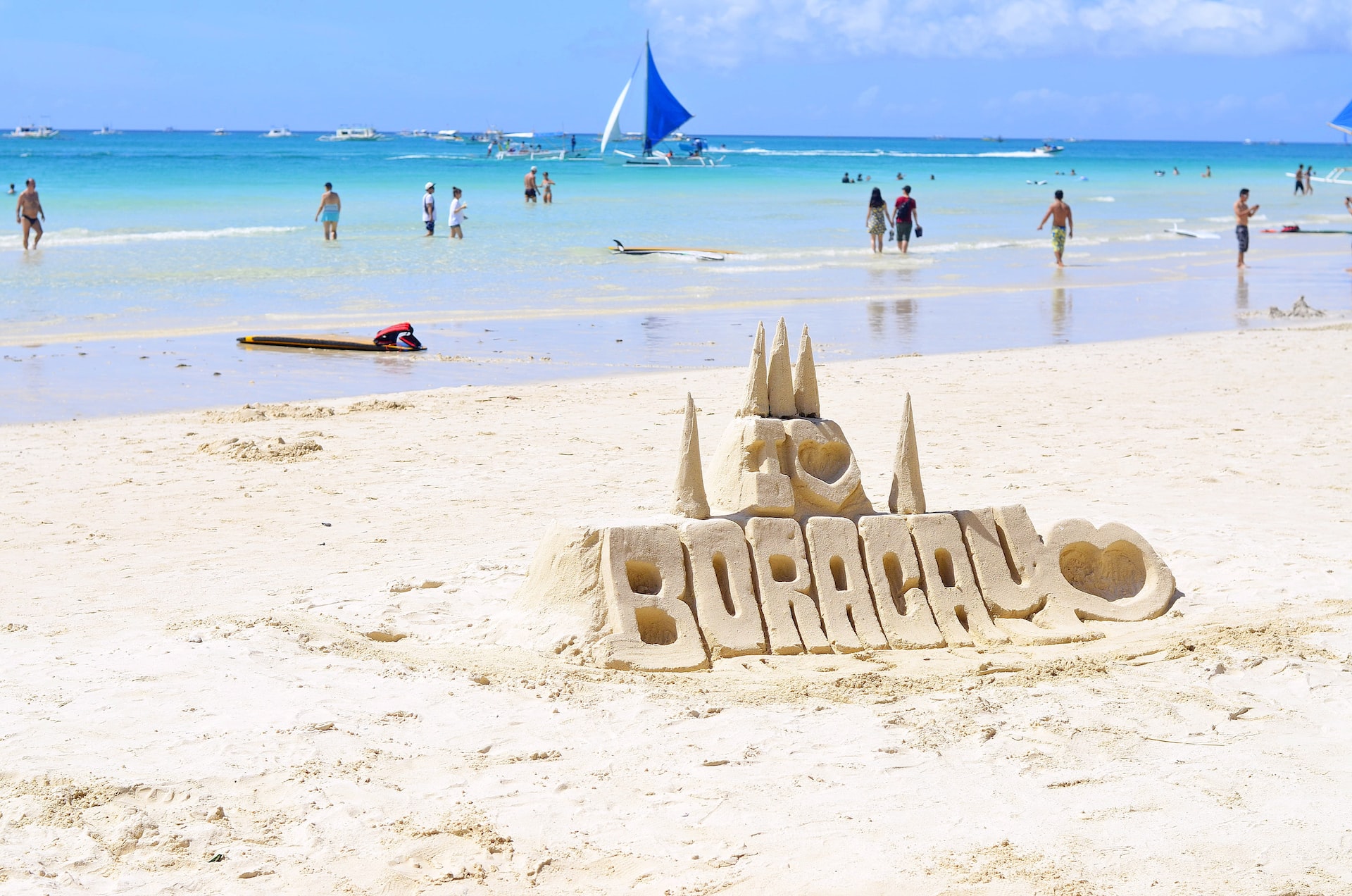 Foreign visitors to Philippines on a beach in Aklan, with the word ‘Boracay formed on the white sand