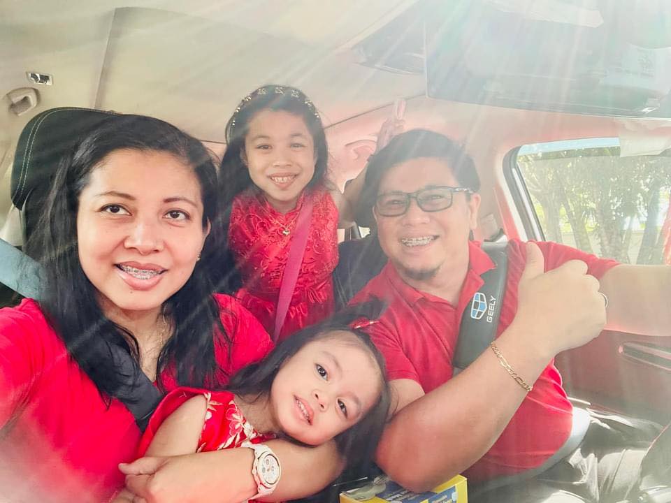 Grace Alviar Viray, her husband and two daughters all in red clothes taking a selfie while inside a car