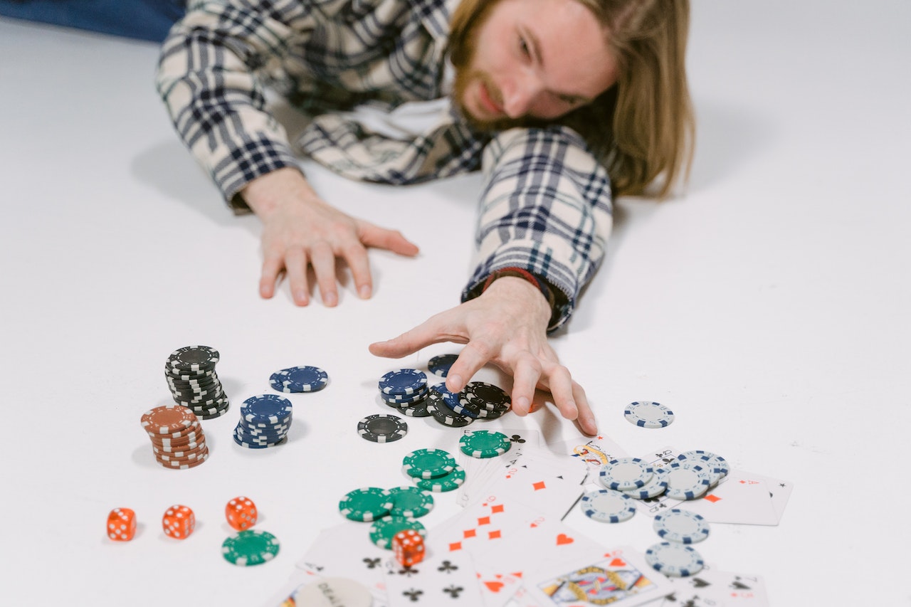 Man with hands reaching to gambling chips and cards