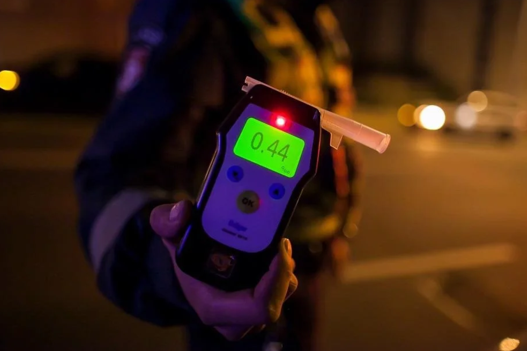 A police officer carrying a breathalyzer in the street